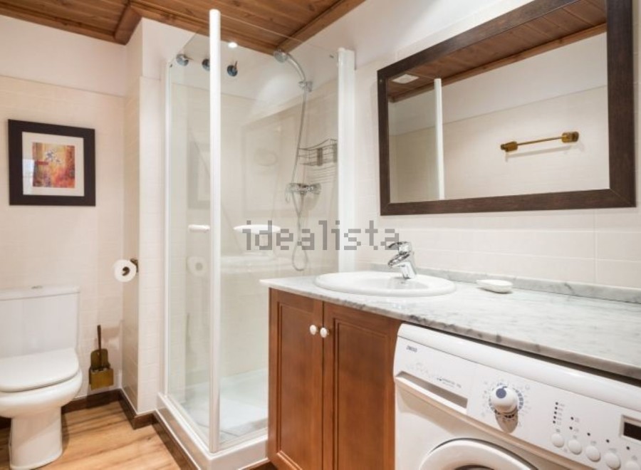 This stunning bathroom boasts a modern design with sleek white fixtures and rich wood cabinetry.