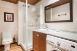 This stunning bathroom boasts a modern design with sleek white fixtures and rich wood cabinetry.