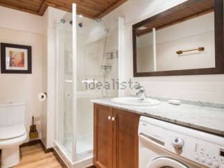 This stunning bathroom boasts a modern design with sleek white fixtures and rich wood cabinetry.