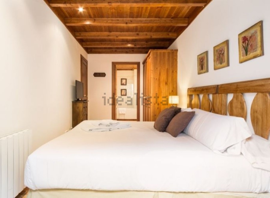 Cozy bedroom with wooden accents and a comfortable bed.