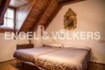 Charming attic bedroom with wooden beams and sloped ceilings.