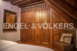 Charming rustic bedroom with built-in wooden wardrobes and beamed ceiling.