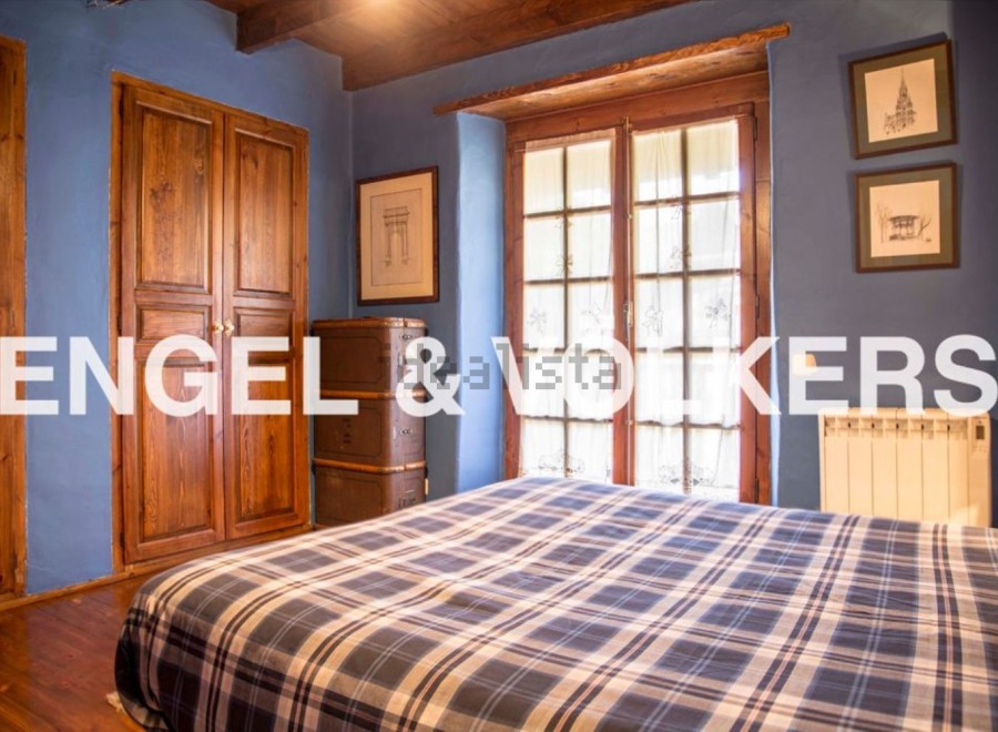 Charming rustic bedroom with wooden floors and double doors.