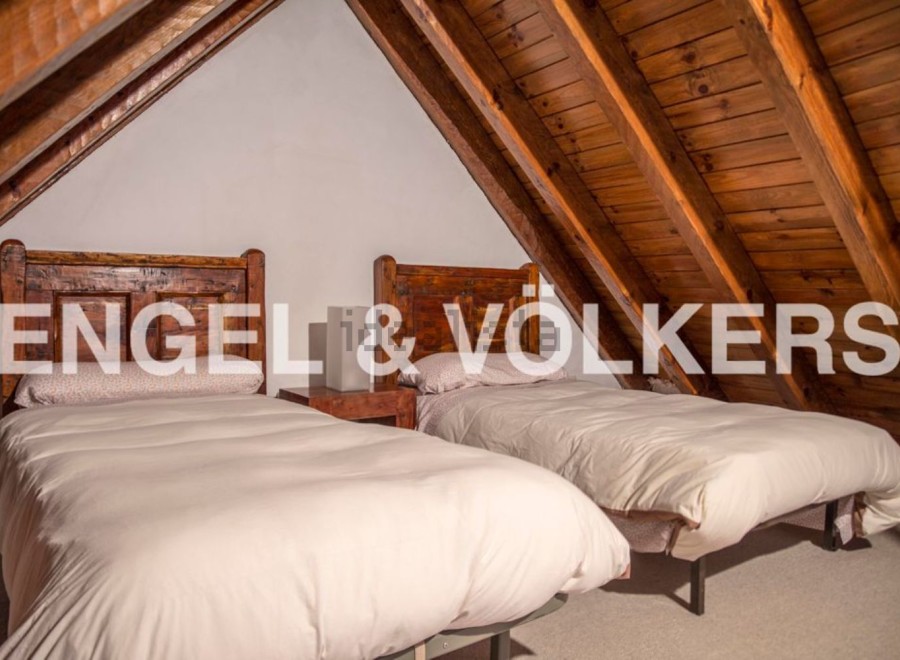 Charming attic bedroom with twin beds and wooden beams.