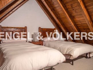 Charming attic bedroom with twin beds and wooden beams.