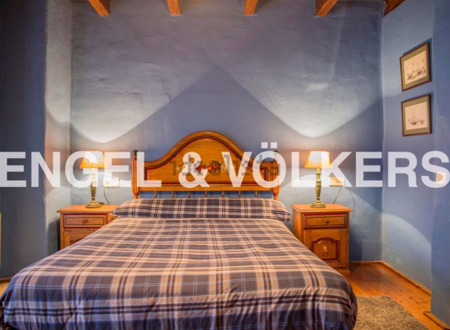 Charming rustic bedroom with wooden headboard and plaid bedding.