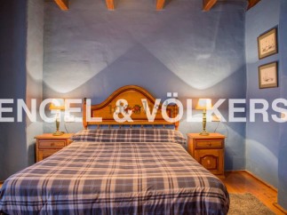 Charming rustic bedroom with wooden headboard and plaid bedding.