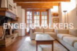 Charming rustic apartment featuring exposed wooden beams, a cozy fireplace, and large windows offering ample natural light.