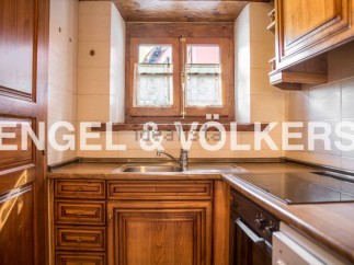 Charming kitchen with rustic wooden cabinetry and a vintage window, offering a cozy and unique atmosphere.