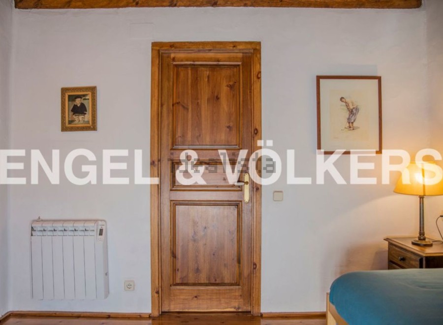 Charming bedroom with wooden door and hardwood floors.