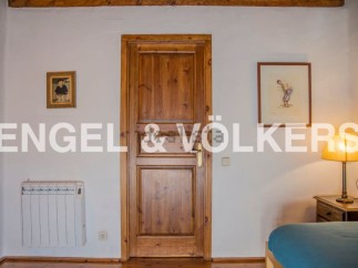 Charming bedroom with wooden door and hardwood floors.