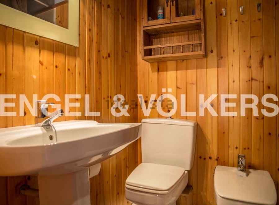 Charming bathroom with wooden walls and a classic white suite.