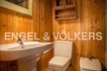 Charming bathroom with wooden walls and a classic white suite.