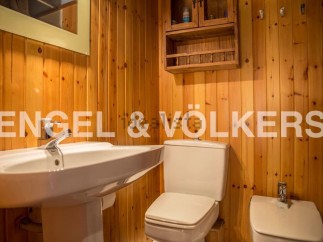 Charming bathroom with wooden walls and a classic white suite.
