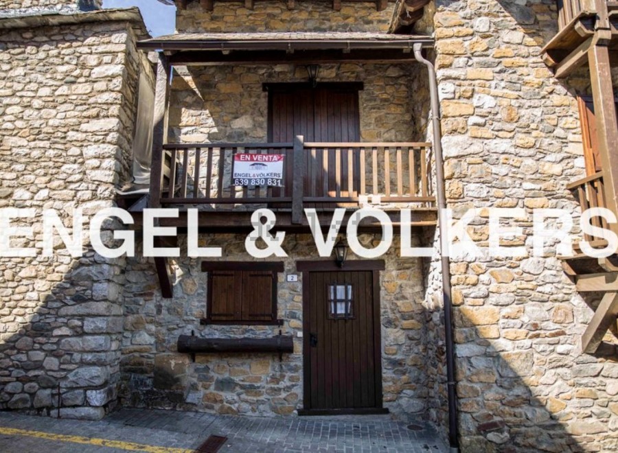 Charming stone house for sale in Andorra, boasting a quaint balcony and traditional wooden features.
