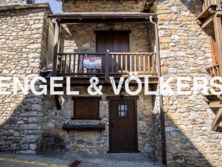 Charming stone house for sale in Andorra, boasting a quaint balcony and traditional wooden features.