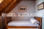Charming attic bedroom with wooden beams and sloped ceilings.