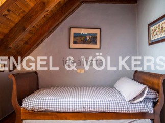 Charming attic bedroom with wooden beams and sloped ceilings.