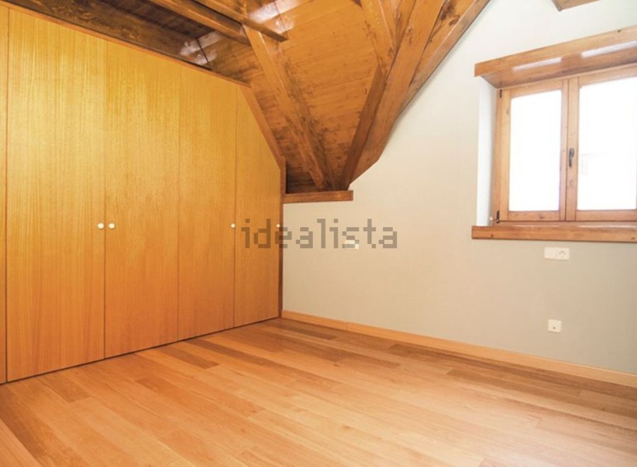 This charming attic bedroom boasts beautiful wooden floors and built-in wardrobes, providing ample storage space.