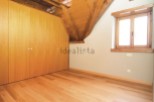 This charming attic bedroom boasts beautiful wooden floors and built-in wardrobes, providing ample storage space.