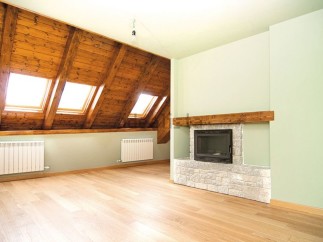 This stunning attic conversion boasts a spacious open-plan layout with gleaming hardwood floors and a cozy fireplace.