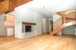 Stunning open-plan living area with hardwood floors and a cozy fireplace.