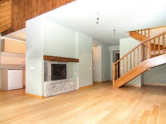 Stunning open-plan living area with hardwood floors and a cozy fireplace.