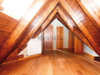 Stunning attic conversion boasts exposed wooden beams and rich hardwood floors.