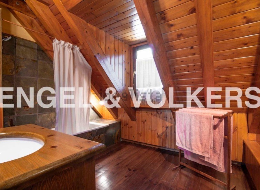 Rustic bathroom with wooden beams and slate tile.