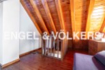 Discover this stunning attic space featuring exposed wooden beams and a charming wooden staircase.