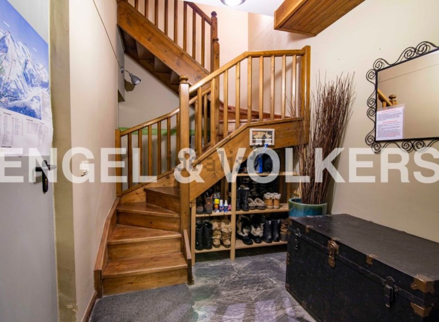 This charming property features a unique wooden staircase as a striking centerpiece.