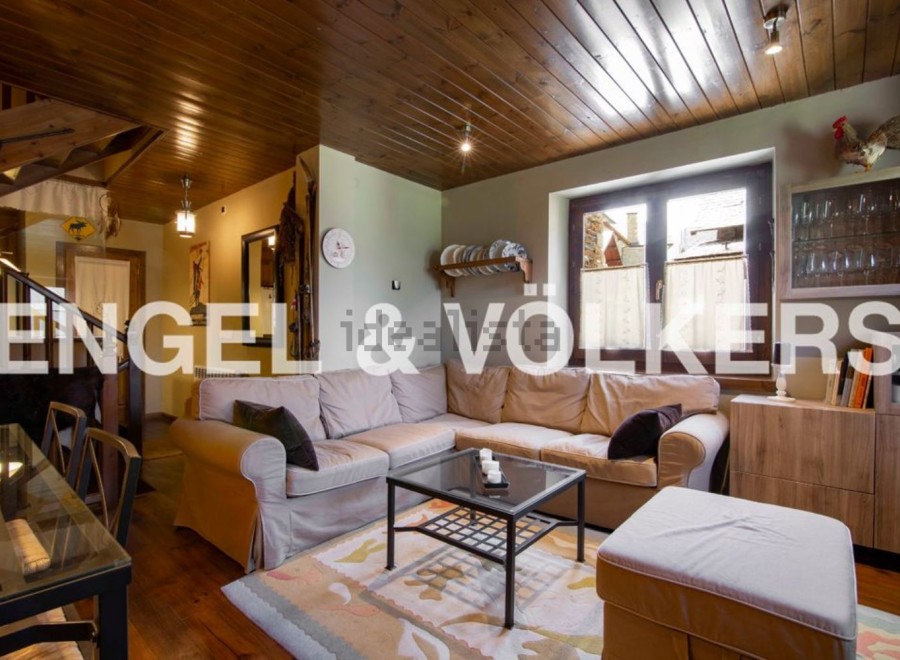 Cozy living room with wooden beams and a large sectional sofa.