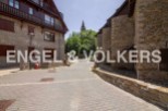 Charming stone buildings line a quaint cobblestone street, creating a picturesque village setting.