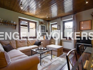 Cozy living room with wooden ceiling and large windows offering ample natural light.