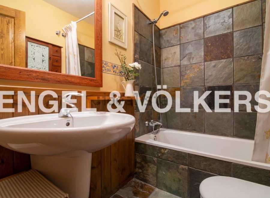 Charming bathroom with rustic wooden accents and slate tile shower.