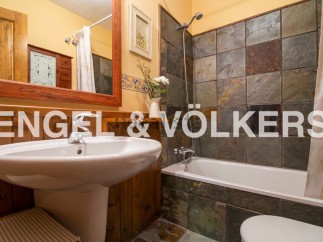 Charming bathroom with rustic wooden accents and slate tile shower.