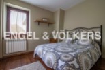 Cozy bedroom with wooden floors and a comfortable double bed.