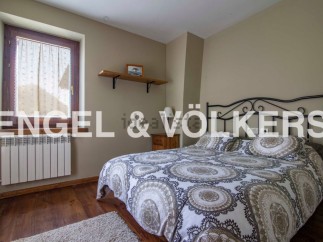 Cozy bedroom with wooden floors and a comfortable double bed.