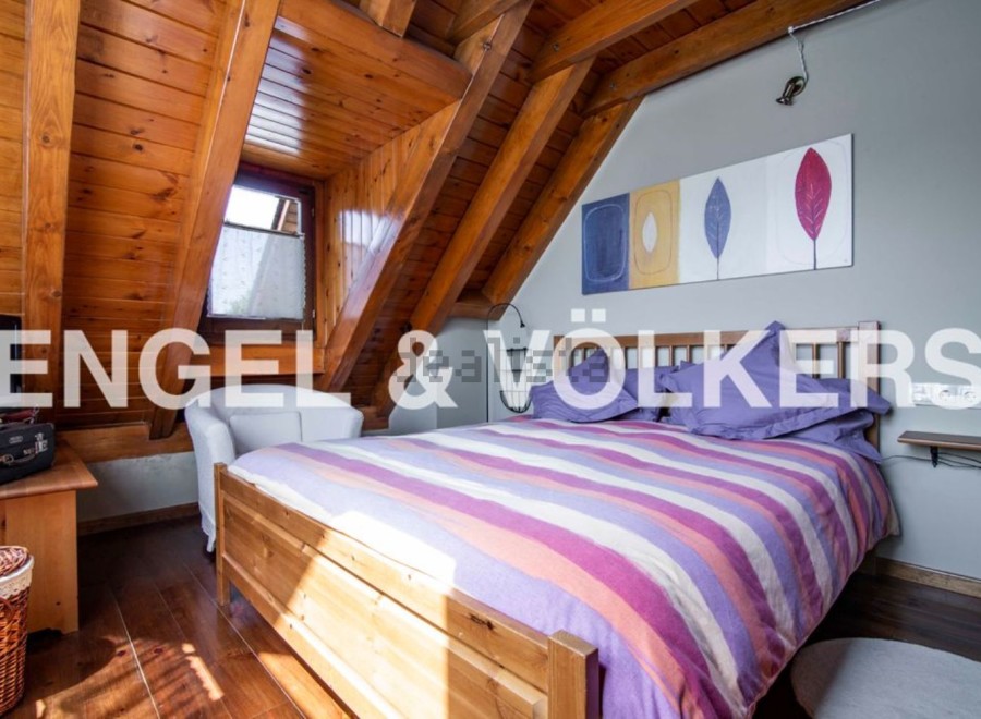 Charming attic bedroom with wooden beams and striped bedding.