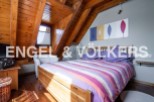 Charming attic bedroom with wooden beams and striped bedding.