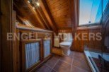 Charming attic bathroom with wooden beams, tiled floor, and a walk-in shower.