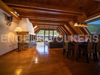 This stunning attic apartment boasts a spacious open-plan living area with hardwood floors, a cozy fireplace, and large windows offering breathtaking views.