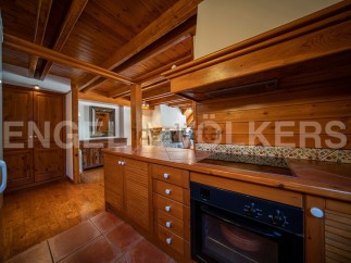 This charming property boasts a rustic-chic kitchen with wooden cabinetry and tiled backsplash.
