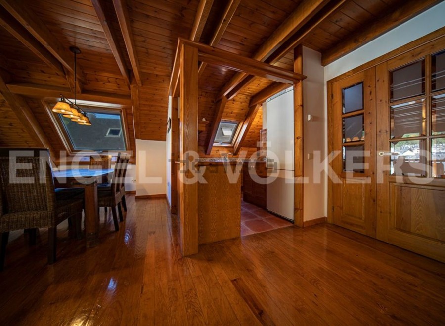 This stunning property boasts a spacious, open-plan living area with gleaming hardwood floors and a charming wooden beamed ceiling.