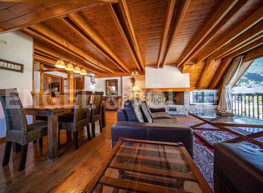This stunning chalet boasts a spacious open-plan living area with a wood-burning fireplace, perfect for cozy nights in.