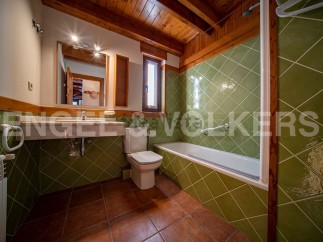 Charming bathroom with green tile and wooden accents.