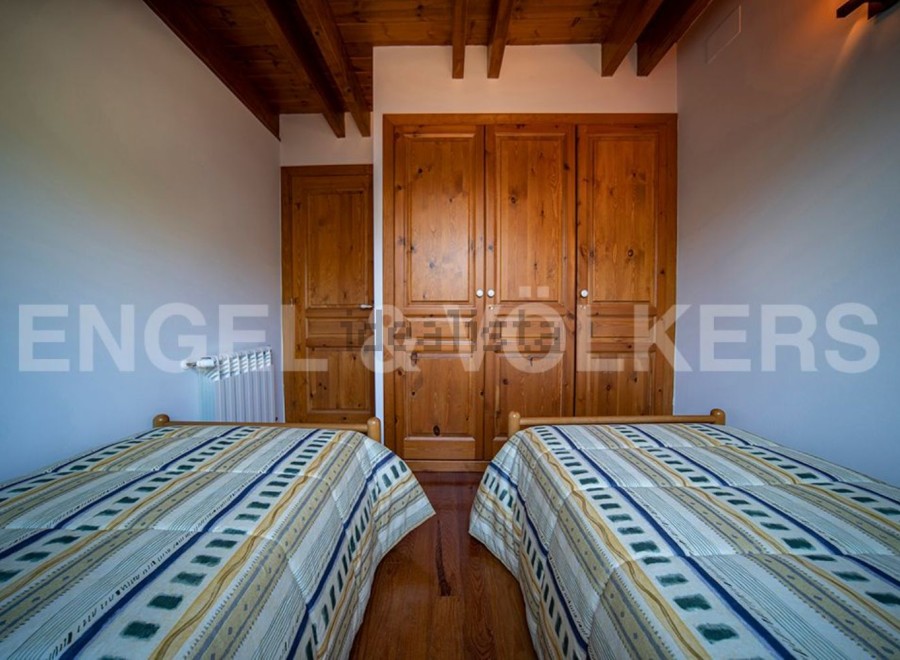 Charming bedroom with twin beds and built-in wooden wardrobe.