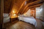 Cozy chalet bedroom with wooden beams and flooring.
