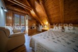Cozy attic bedroom with wooden beams and mountain views.
