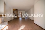 Spacious open-plan living area with wooden flooring and a stunning spiral staircase.